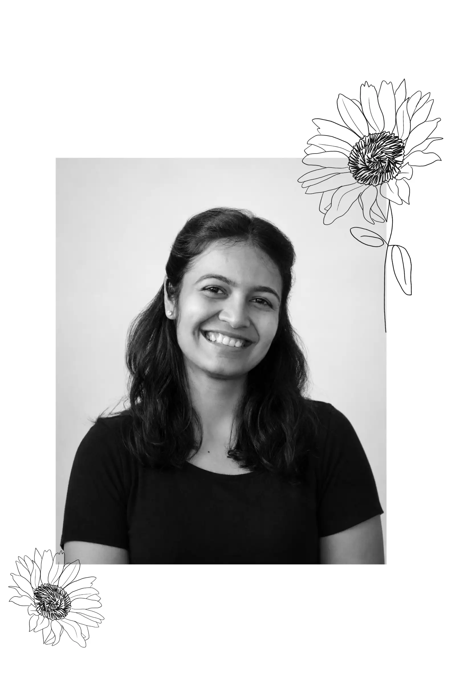 Sakshi Diwan, smiling, in a black t-shirt against a pale wall