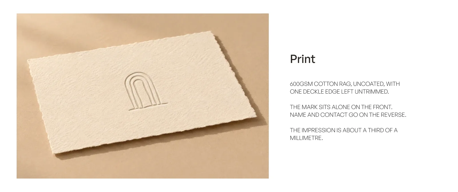 A Mrida business card blind debossed into 600gsm uncoated cotton rag with one deckle edge left untrimmed, the mark alone on the front and an impression about a third of a millimetre deep.